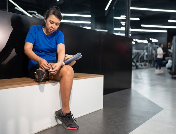 在健身房里，一名亚洲妇女带着假腿准备锻炼图片下载