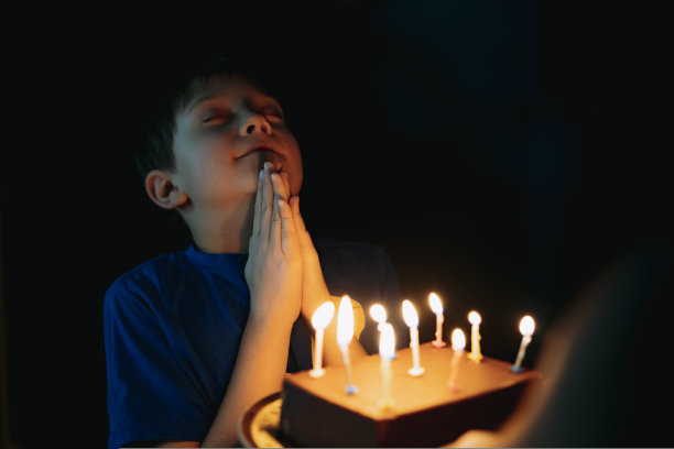 可爱的白人小男孩在他9岁生日时，在吹灭蛋糕上的蜡烛前许了一个愿图片下载