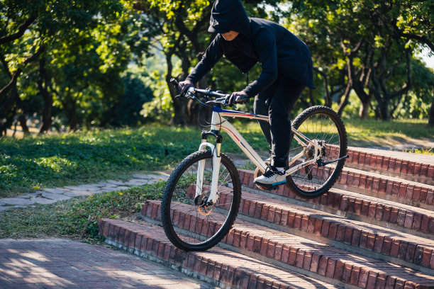 一个免费骑车的女人骑着自行车下了城市的楼梯图片下载