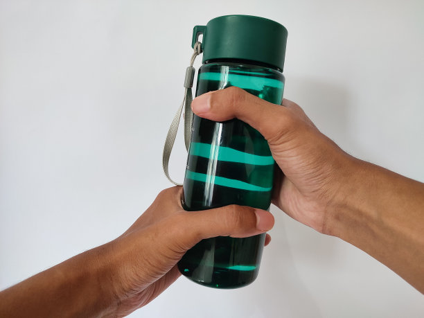 手拿装满水的塑料瓶图片下载