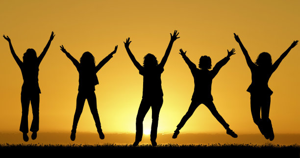 快乐的朋友在夕阳的背景下跳跃图片下载