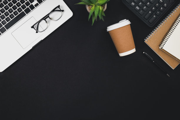 笔记本电脑，咖啡杯和计算器平铺黑色背景，俯视图。图片下载