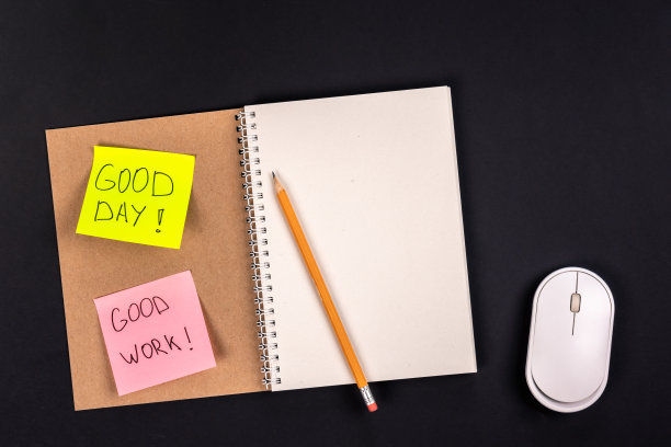 记事本，电脑鼠标和纸贴纸在一个黑暗的背景，俯视图。图片下载