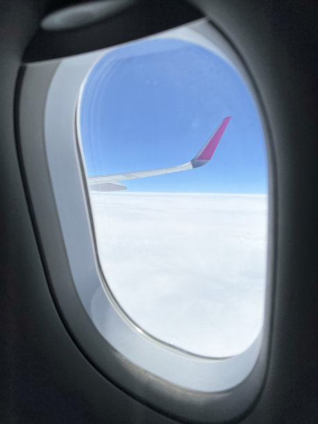 从飞机窗口看到的风景。美丽的云景和蓝天。透过飞机窗户看到的白云之上的美丽全景。乘飞机旅行概念图片下载