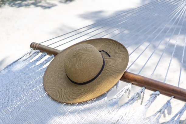 一顶草帽躺在马尔代夫的吊床上。旅游和热带度假的概念图片下载