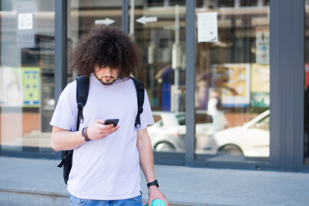 年轻人在户外散步时使用手机图片下载