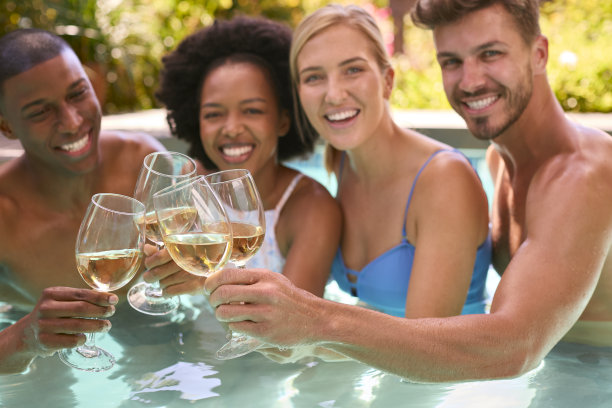 一群来自不同文化的朋友在泳池里喝酒度假的照片图片下载