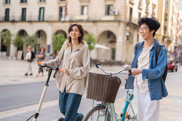 现代时尚的中国夫妇，骑着自行车和电动滑板车穿梭于城市之间图片下载
