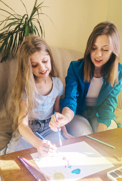 母女俩画画。美术老师教授使用水彩颜料、水粉的技巧，以及如何正确握笔。快乐童年的概念。微笑的人。有趣的情绪。图片下载