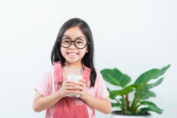 亚洲女孩用玻璃杯喝牛奶图片下载