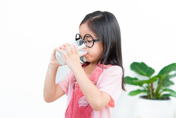 亚洲女孩用玻璃杯喝牛奶图片下载