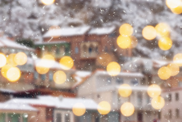 美丽的冬季模糊的第比利斯城市背景与飘落的雪和散景灯图片下载