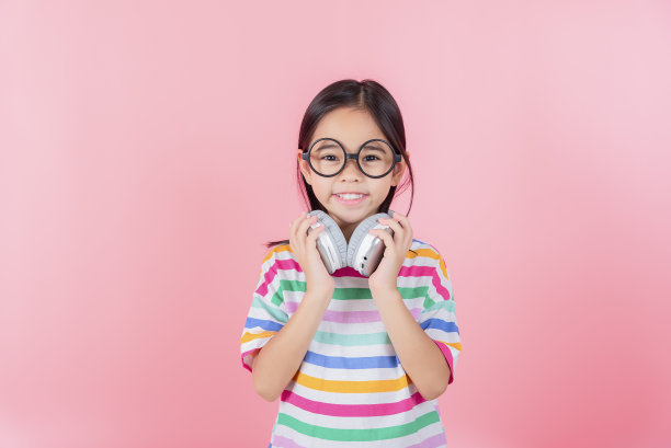 亚洲可爱的小女孩戴上耳机，用笔记本电脑和老师视频通话，在电脑上在线学习，在家上学的概念图片下载