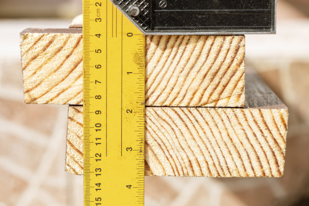 男子测量木板。木匠检查木板的质量。图片下载