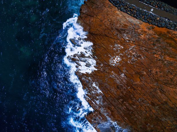 鸟瞰澳大利亚岩石海滩周围清澈湛蓝的海水。图片下载