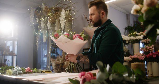 集中的男花商包裹鲜花花束图片下载