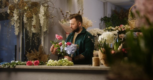专业花艺师给花添加树枝图片下载