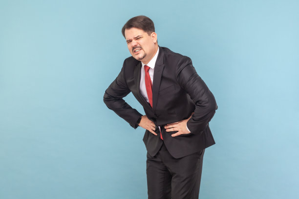 生病的不健康的人站在那里，肚子很痛，摸着肚子，皱着眉头。图片下载