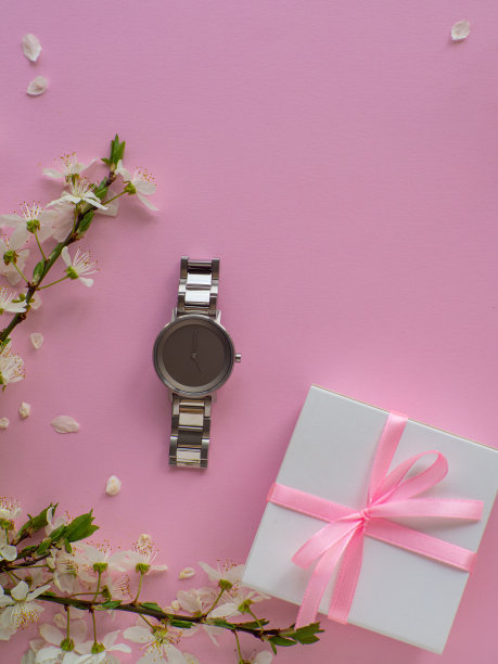 女性腕表粉红色的背景与樱花和复制空间图片下载