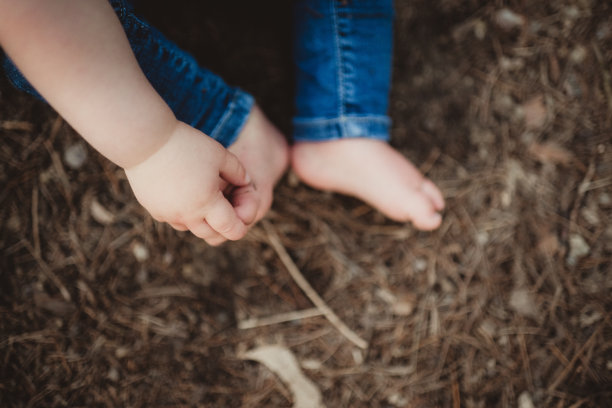 胖乎乎的婴儿手抓着他的脚趾图片下载