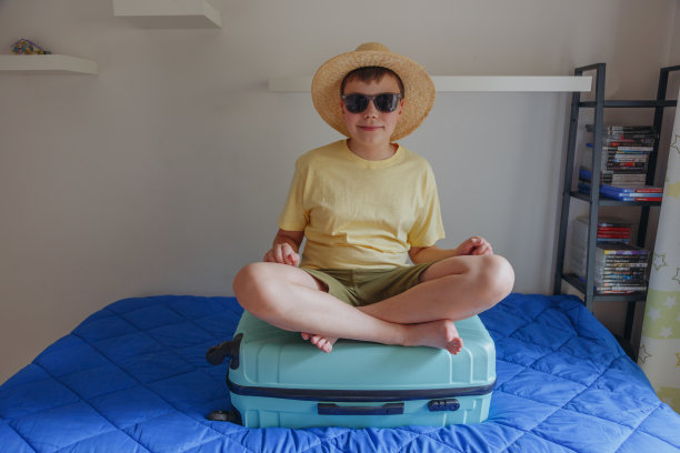 放假时，构图的孩子带着皮箱坐在沙发上。图片下载