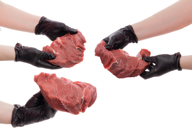 牛扒被隔离在白色背景上。厨师戴着黑色硅胶手套，手里拿着生肉。图片下载