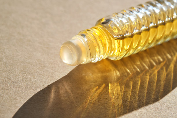 米色背景油辊香水。图片下载