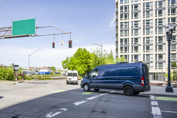 商业货运小货车在有红绿灯的城市十字路口运送货物图片下载