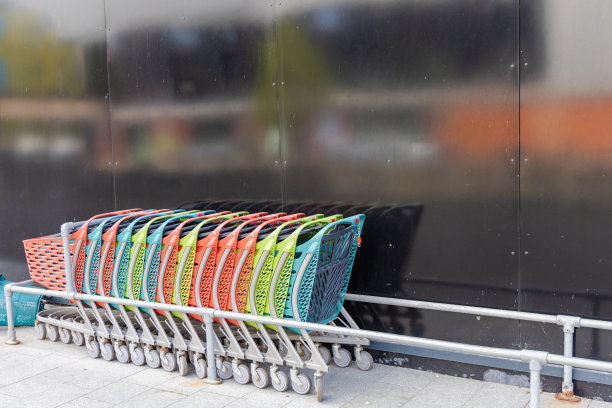 超市附近一排五颜六色的空购物车。图片下载