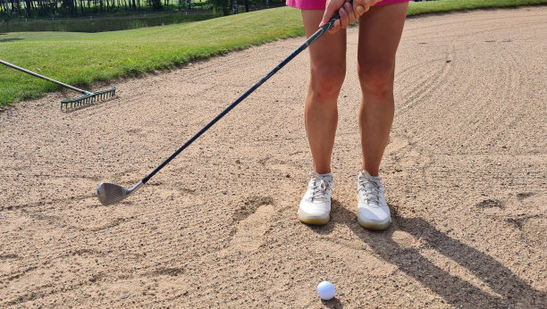 从沙坑出发前，高尔夫球和球杆的特写图片下载