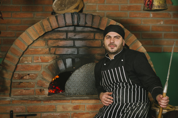 面包师在砖炉里做面包图片下载
