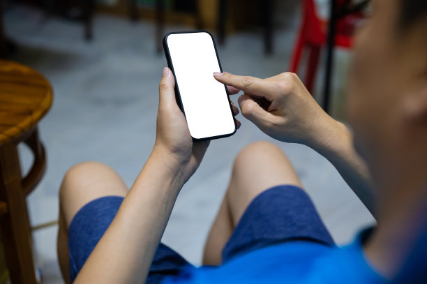 成年男子在沙发上使用黑白屏幕的智能手机图片下载