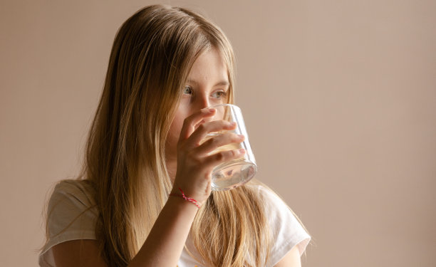 金发女孩喝了一杯水在家里凑近图片下载