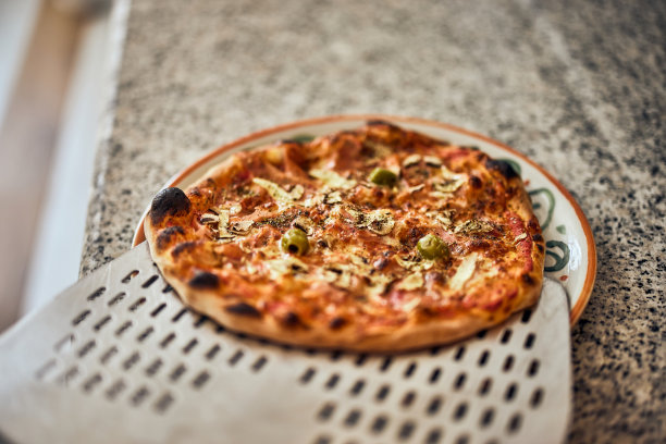 刚做的披萨放在盘子里，看起来很好吃。图片下载