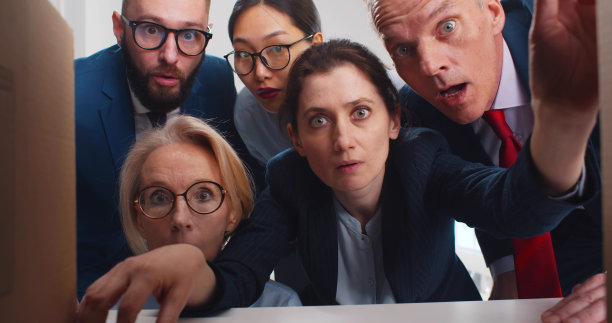 一群惊讶的商人在看纸盒里面图片下载