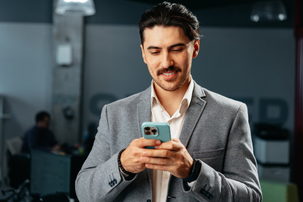 穿着正装的阿拉伯帅哥在办公室用智能手机图片下载