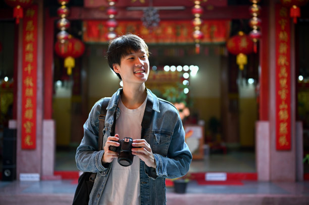 快乐的亚洲男游客环顾寺庙，独自在古城观光。图片下载