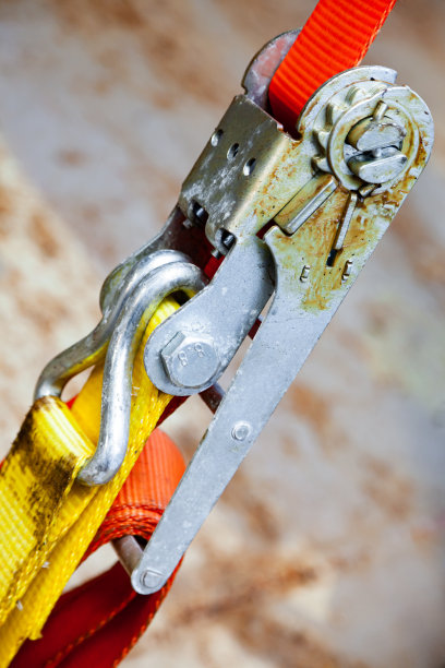 拉紧的货物带，橙色，棘轮锁，对角特写。图片下载