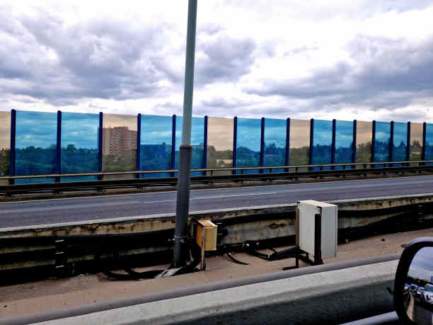 鸟，安全，隔音墙的蓝色玻璃在公路桥梁上嵌入金属梁，在街上。道路交通噪音减少。钢索的安全保护，防止掉到人身上图片下载