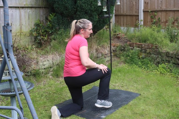 一张中年妇女在自家花园里做有氧和无氧混合运动的照片图片下载