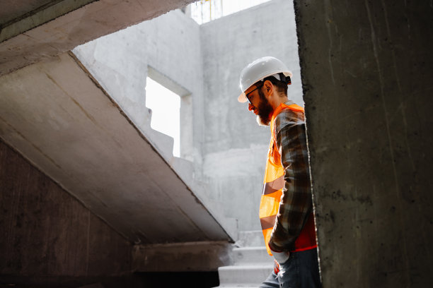 年轻的建筑商人站在他工作的工地上图片下载