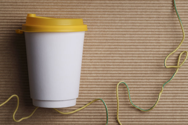 白色空白外卖纸回收杯，黄色盖子，棕色罗纹背景，模拟，模板，空间为您的文字，广告。图片下载