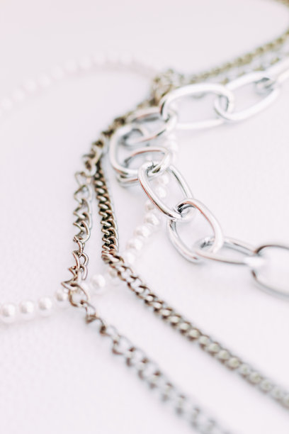 在白色的美学背景上镶有珠宝链的白色珠子项链图片下载