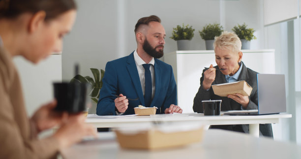 商务人士在办公室吃外卖午餐，讨论工作图片下载