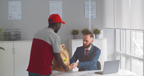 给在职商人送外卖的非裔美国快递员图片下载