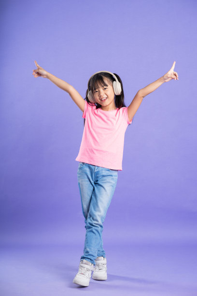 可爱的亚洲女婴在紫色背景上摆姿势图片下载