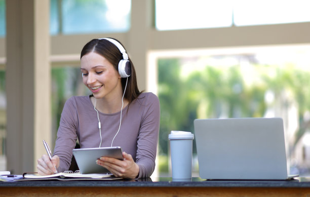 用平板电脑写学习笔记的女人。图片下载