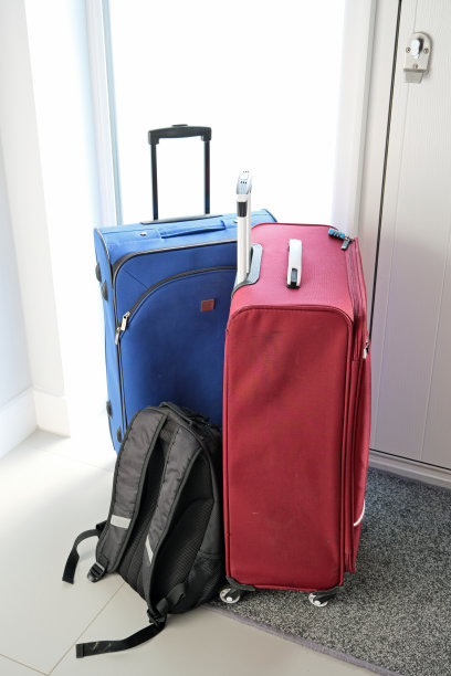 假期的行李。两个带轮子的手提箱和一个帆布背包。概念，到达或离开的旅行。图片下载