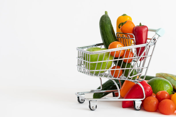 装满蔬菜的购物车。素食，健康饮食。白色背景，复制空间。图片下载