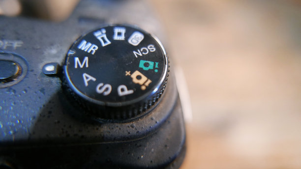 相机转盘，特写镜头。相机功能。相机按钮。桌上有一台照相机。木桌上的数码相机。摄影师的工作。相机的一天。摄影师。老式数码相机图片下载